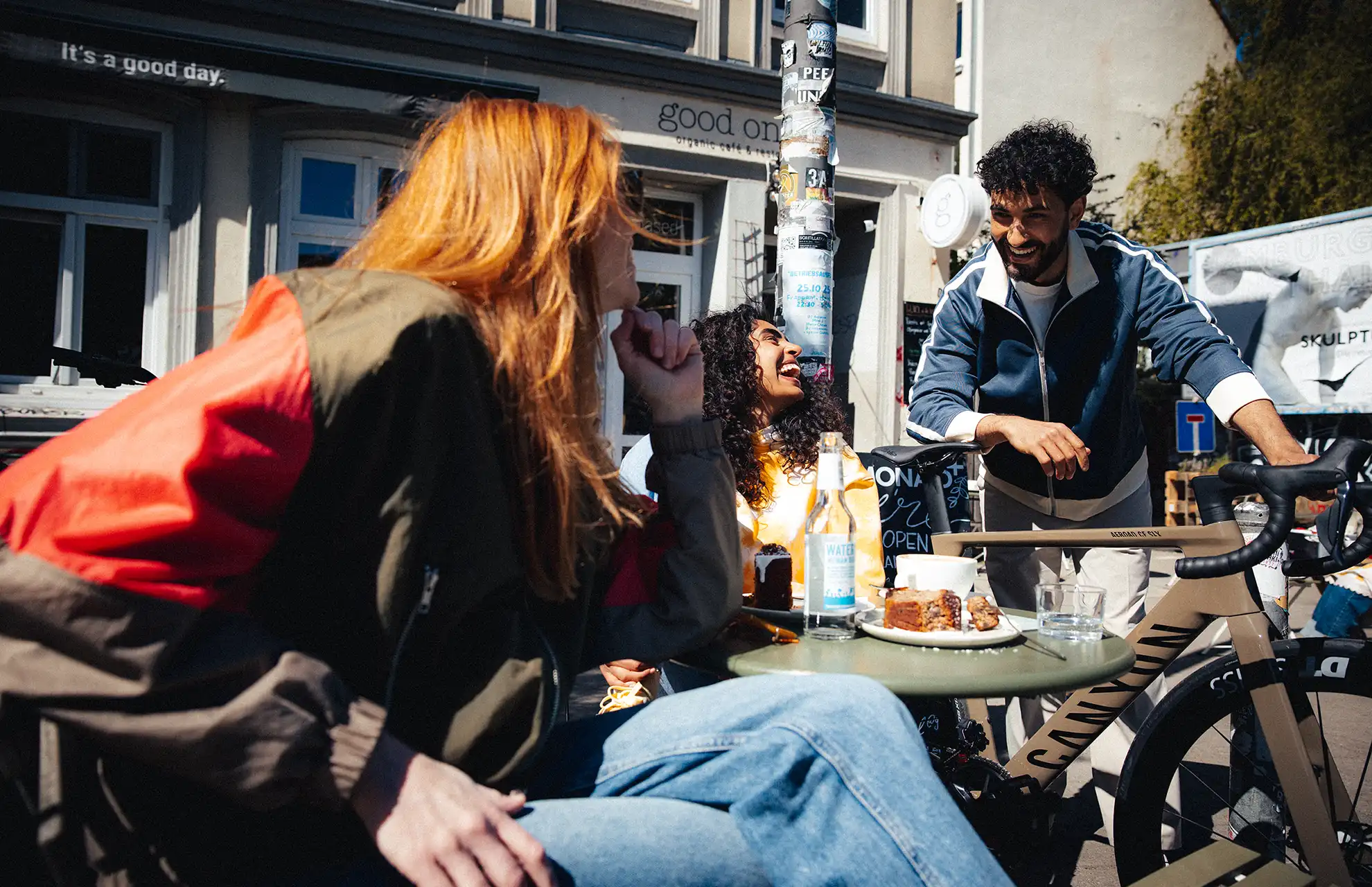 Junge Leute im Cafe. Ein Freund zeigt sein Gravelbike von JobRad